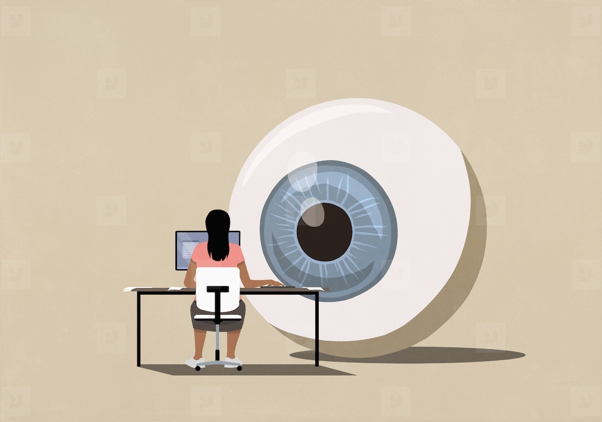Large surveillance eyeball watching woman using computer at desk