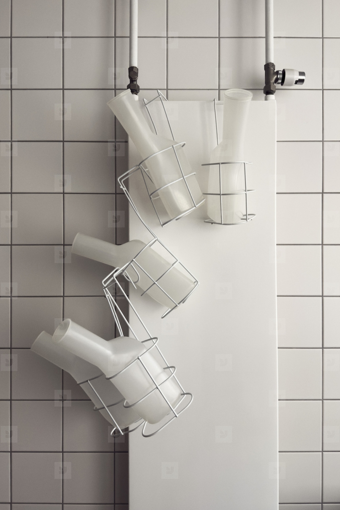 Urine bottles in racks against while tile