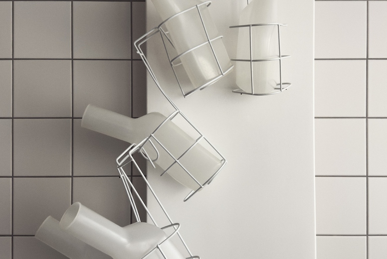Urine bottles in racks against while tile