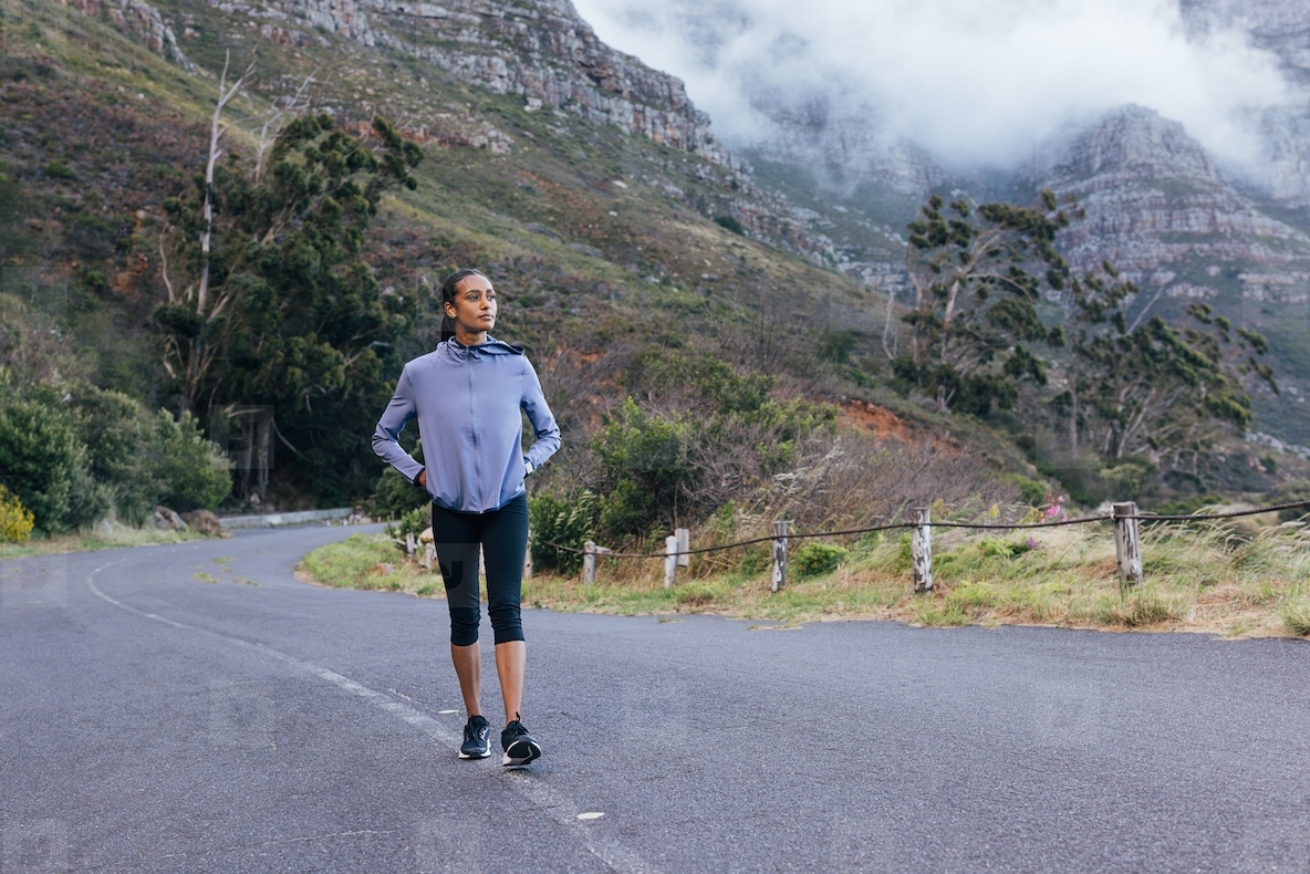 Full length of a young slim female doing a morning walk in a natural park  Confident woman enjoying the view while walking