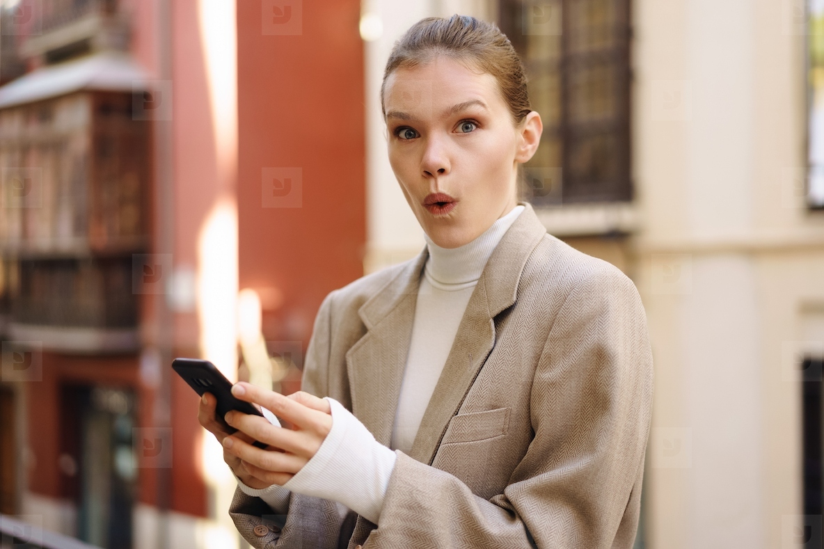 A Happy and Smiling Woman Engaged Deeply with Her Smartphone in a Lively Urban Setting