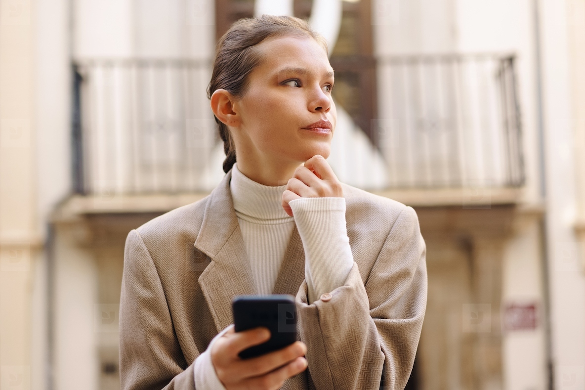 A young professional focuses on their smartphone amid a lively  energetic urban setting