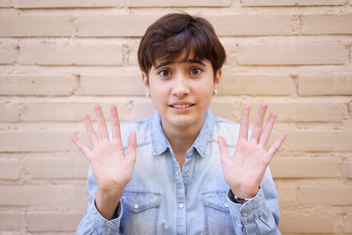 A Young Woman Displaying a Sense of Openness and Inviting Communication with Raised Hands