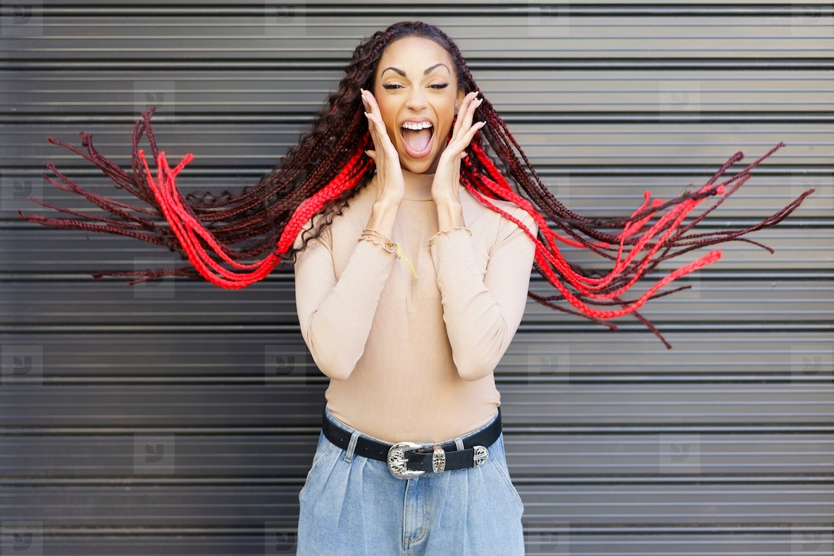 An Excited Woman with Striking Red Braids Expressing Pure Joy Against a Stylish Background