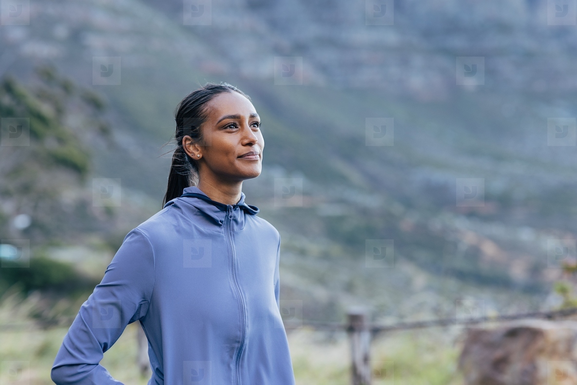 Portrait of a positive woman enjoying a morning walk against a stunning view in the natural park