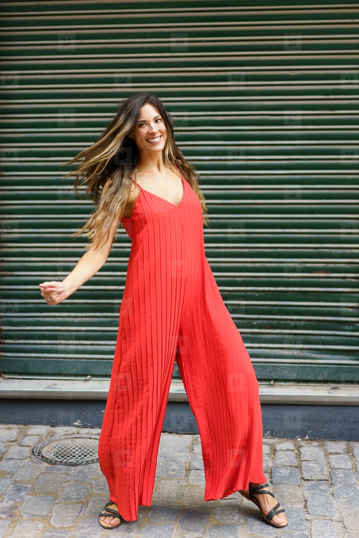 A vibrant red jumpsuit featuring a dynamic dance pose set against a lively green background