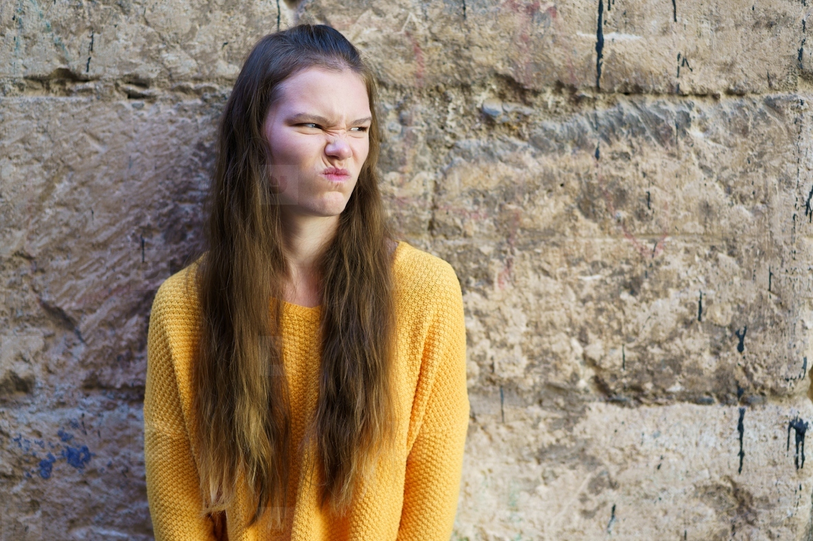 A cheerful and colorful youthful expression captured against a rough textured wall backdrop