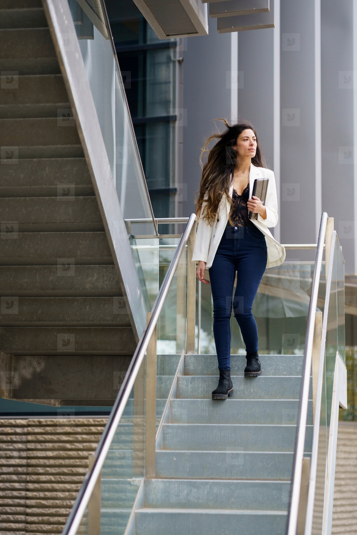 A Stylish Young Woman Confidently Walking Down a Modern and Trendy Staircase with Grace