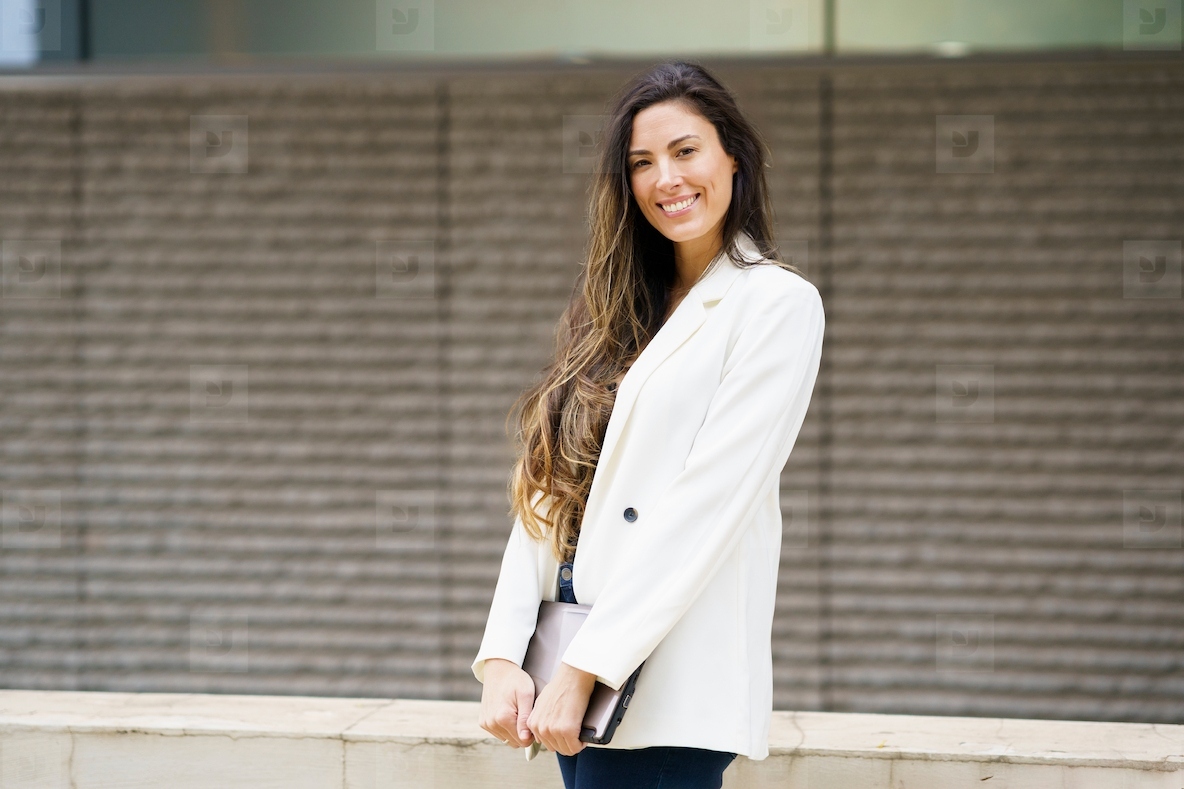 A Confident and Stylish Young Woman is Posing Outdoors while Wearing a Chic Blazer