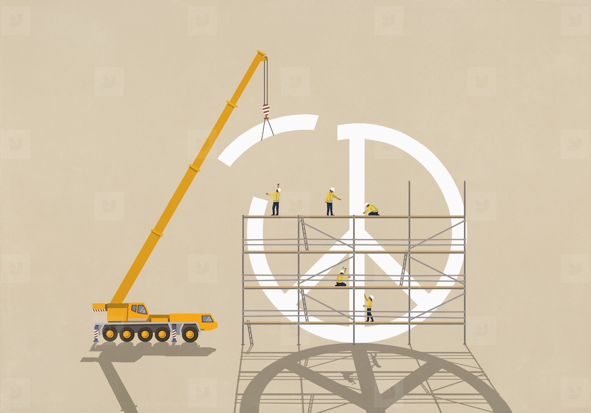 Construction workers on scaffolding below crane assembling large peace sign