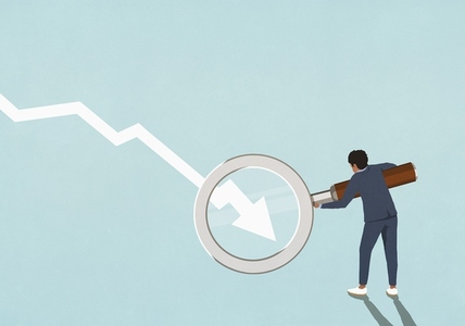 Businessman holding magnifying glass over descending chart arrow