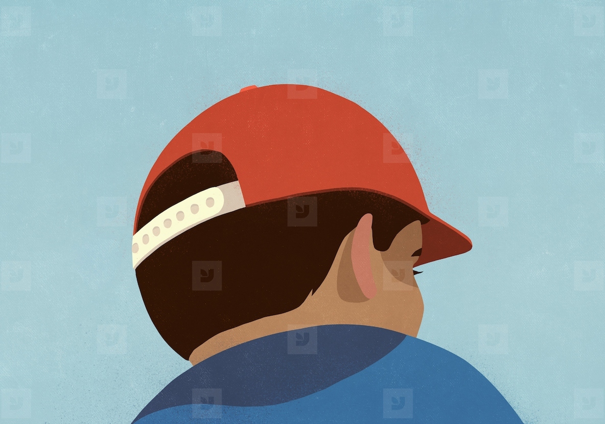 Low angle view brunette boy in red baseball cap looking away