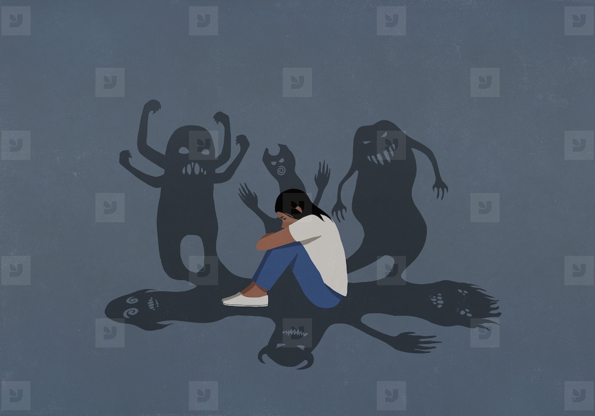 Shadows of monsters surrounding anxious teenage girl sitting and hugging knees