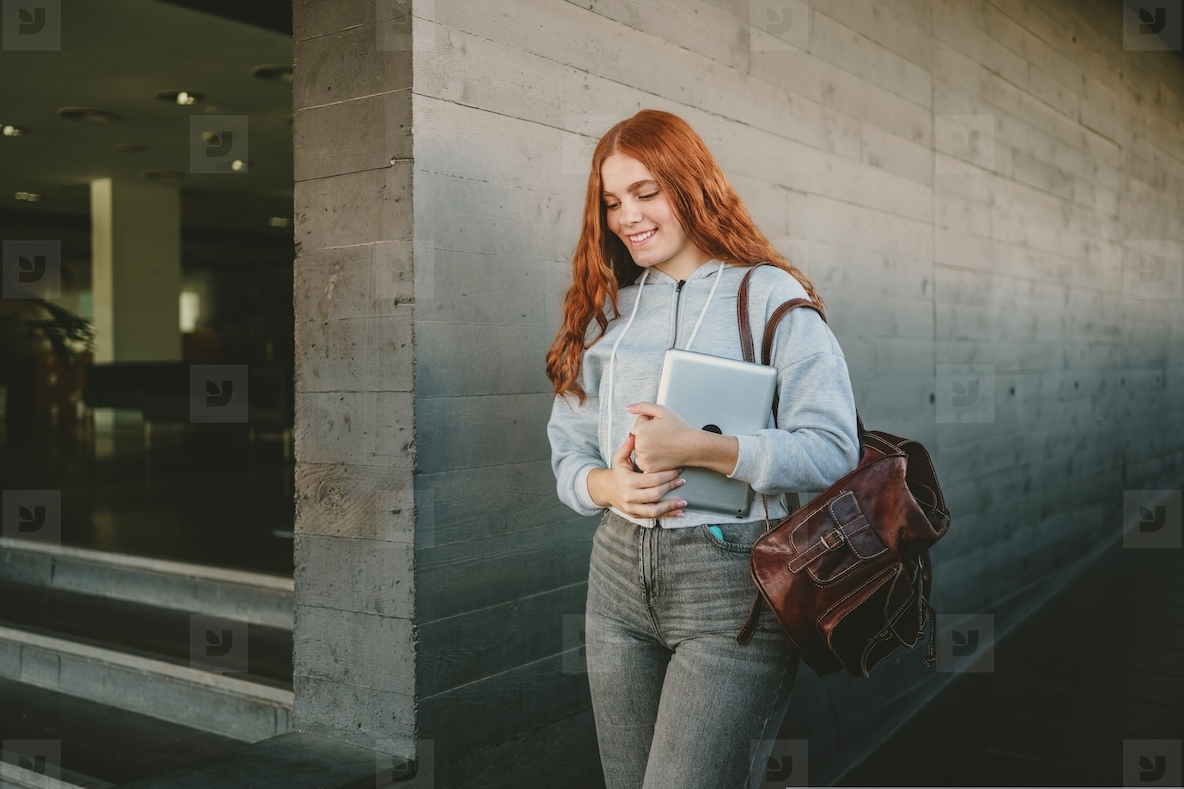 A young woman confidently using a laptop while in an urban setting  surrounded by modernity