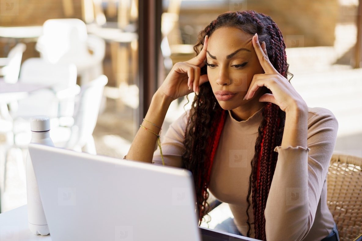 A Focused Woman Engaged in Productive Work on Her Laptop in a Modern and Stylish Workspace