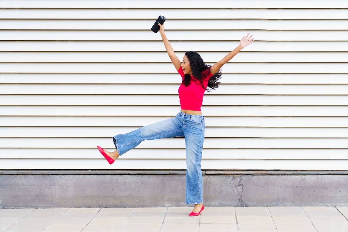 A Joyful Young Woman Happily Dancing in a Lively Urban Setting Full of Energy and Life