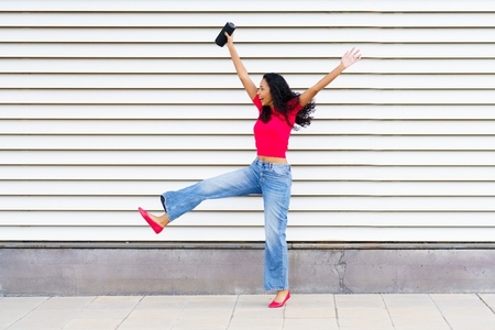 A Joyful Young Woman Happily Dancing in a Lively Urban Setting Full of Energy and Life