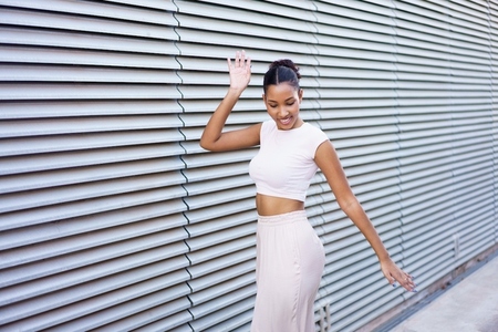 A Charming Young Woman Posing Delightfully Against a Modern and Stylish Background Environment