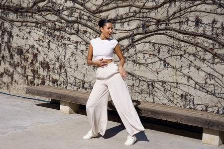 A dynamic dance pose against a vibrant wall backdrop  showcasing elegance and energy