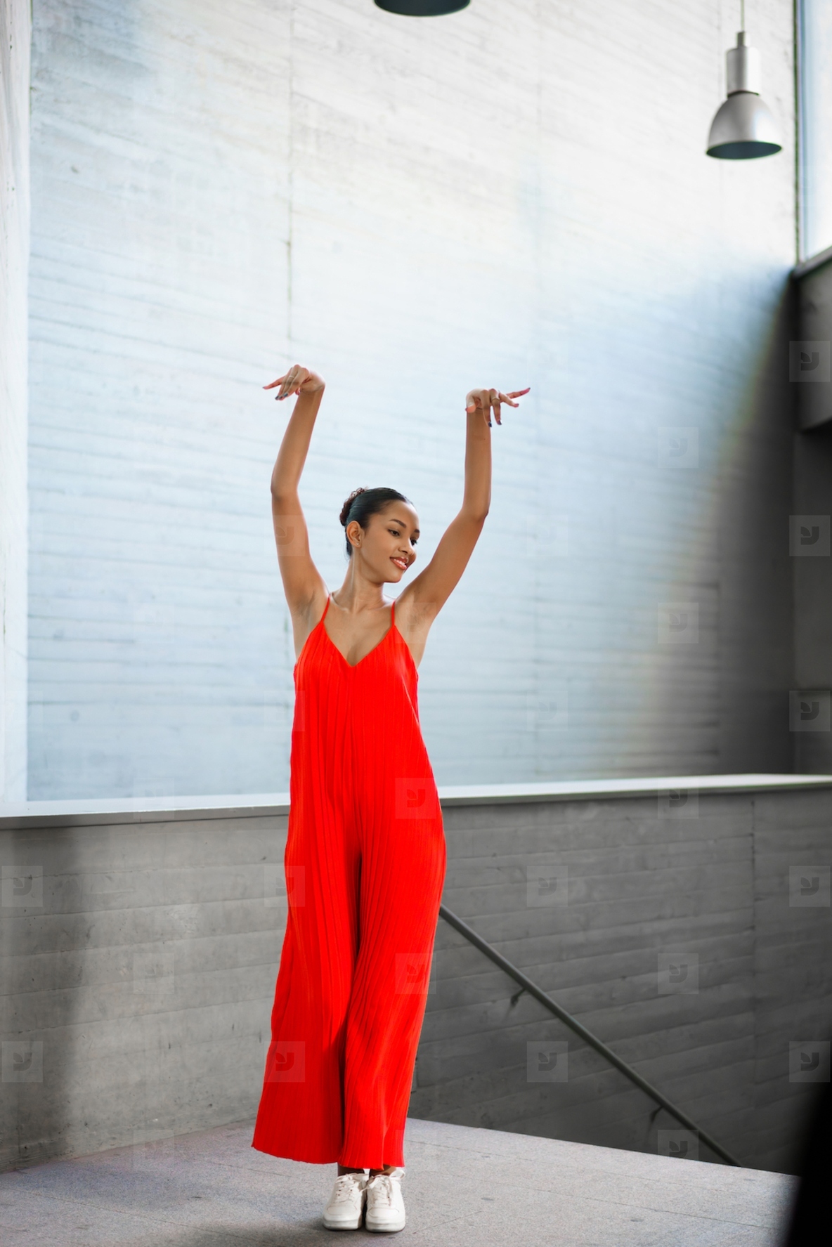 An Elegant Dancer Dressed in Vibrant Red Attire Poses Beautifully in a Modern Interior