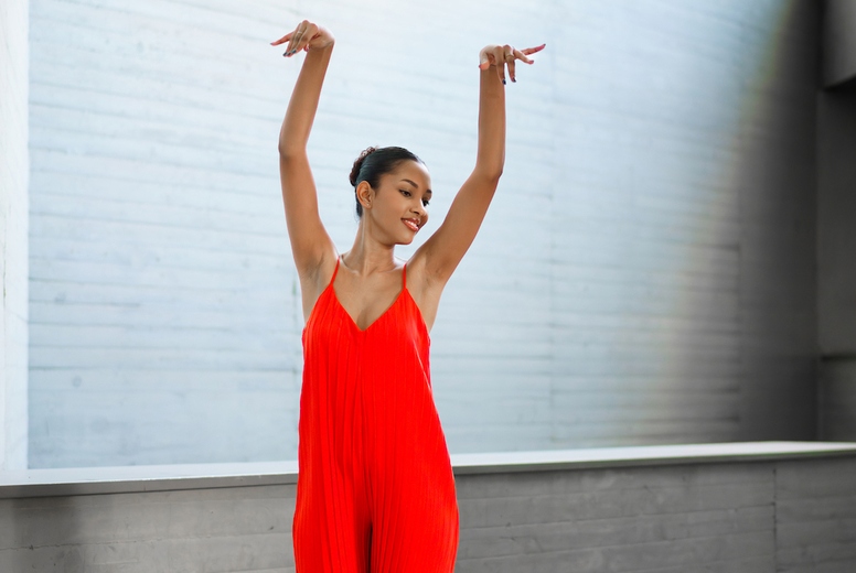 An Elegant Dancer Dressed in Vibrant Red Attire Poses Beautifully in a Modern Interior