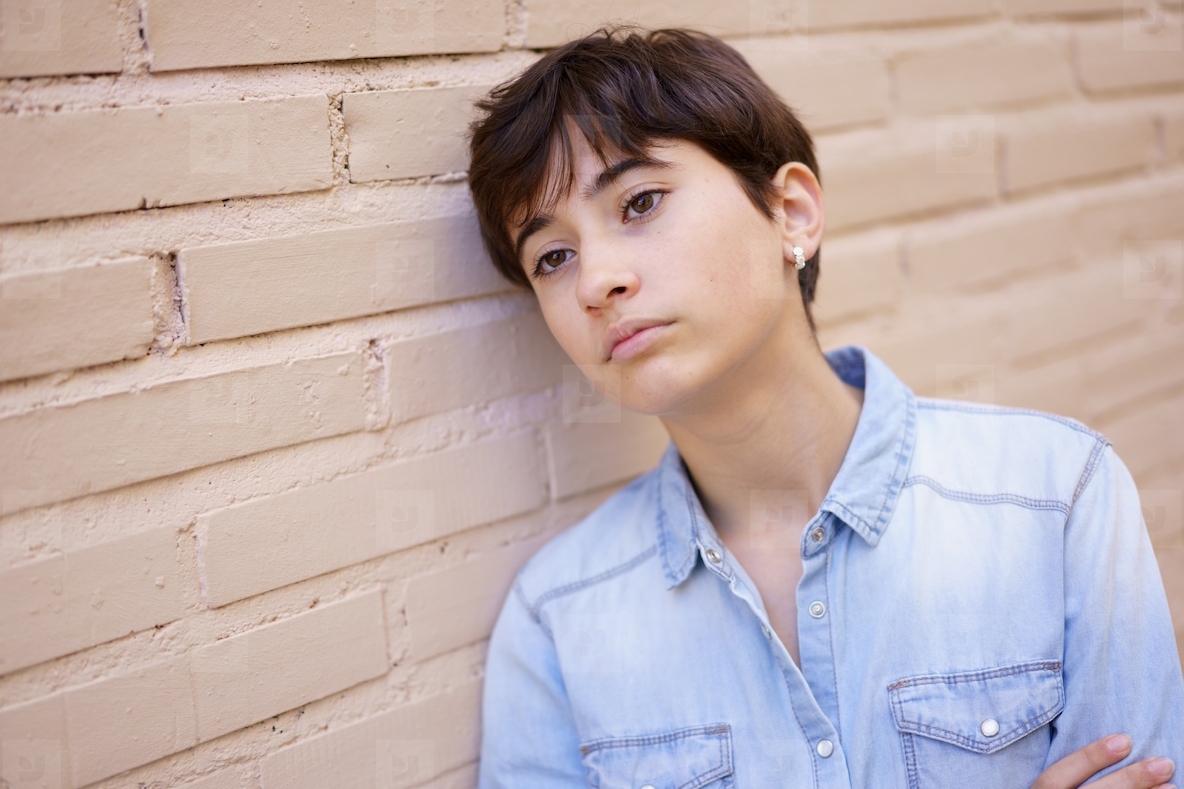 A Young Person Engaged in Contemplation as They Lean Against a Wall Deep in Thought