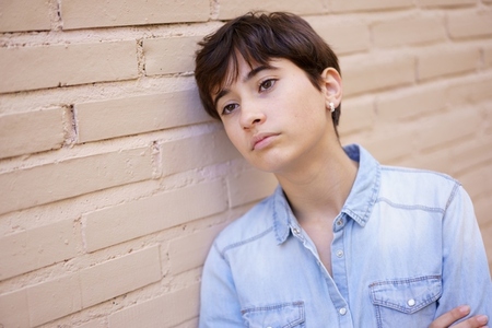 A Young Person Engaged in Contemplation as They Lean Against a Wall  Deep in Thought