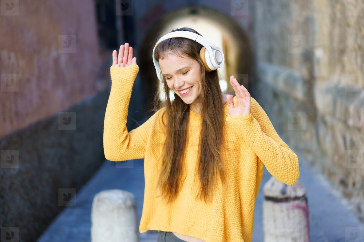 A Joyful Young Woman Is Enjoying Listening to Music While Outdoors and Loving Life