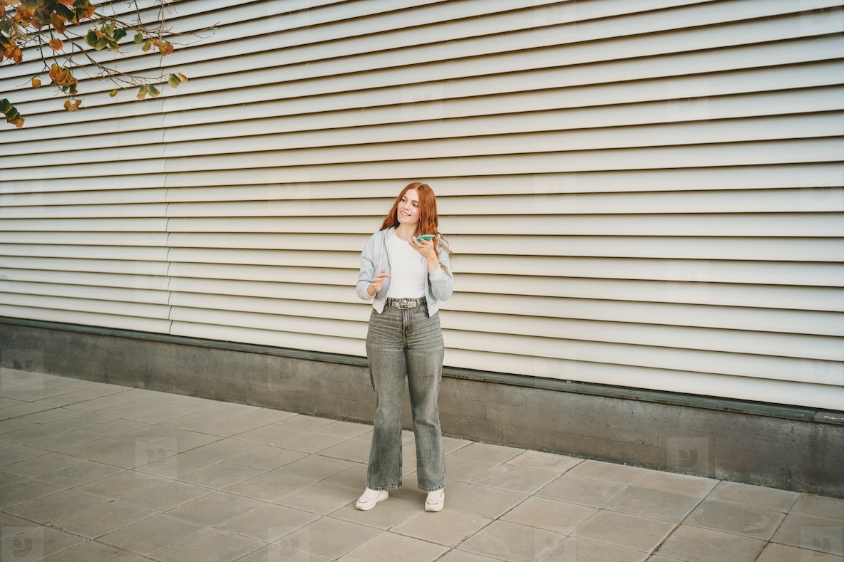 A stylish young woman confidently poses against a backdrop of modern architecture