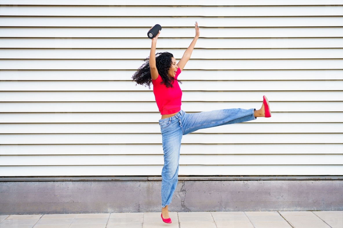 Dynamic and Joyful Dance Pose Captured Against a Striped Background for a Vivid Effect