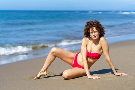 Slim woman in bikini on sunny coast Slim woman in bikini on sunny coast