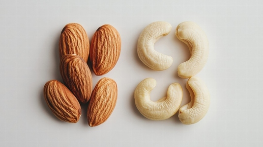 Almonds and cashews arranged on minimalist white background