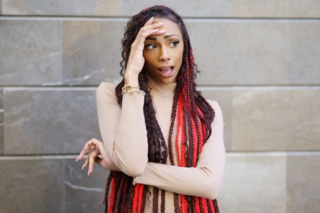 A Stylish Woman with an Uniquely Designed Hairstyle Posing Against a Modern Backdrop