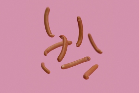 Bavarian sausages falling against pink background Bavarian sausages falling against pink background