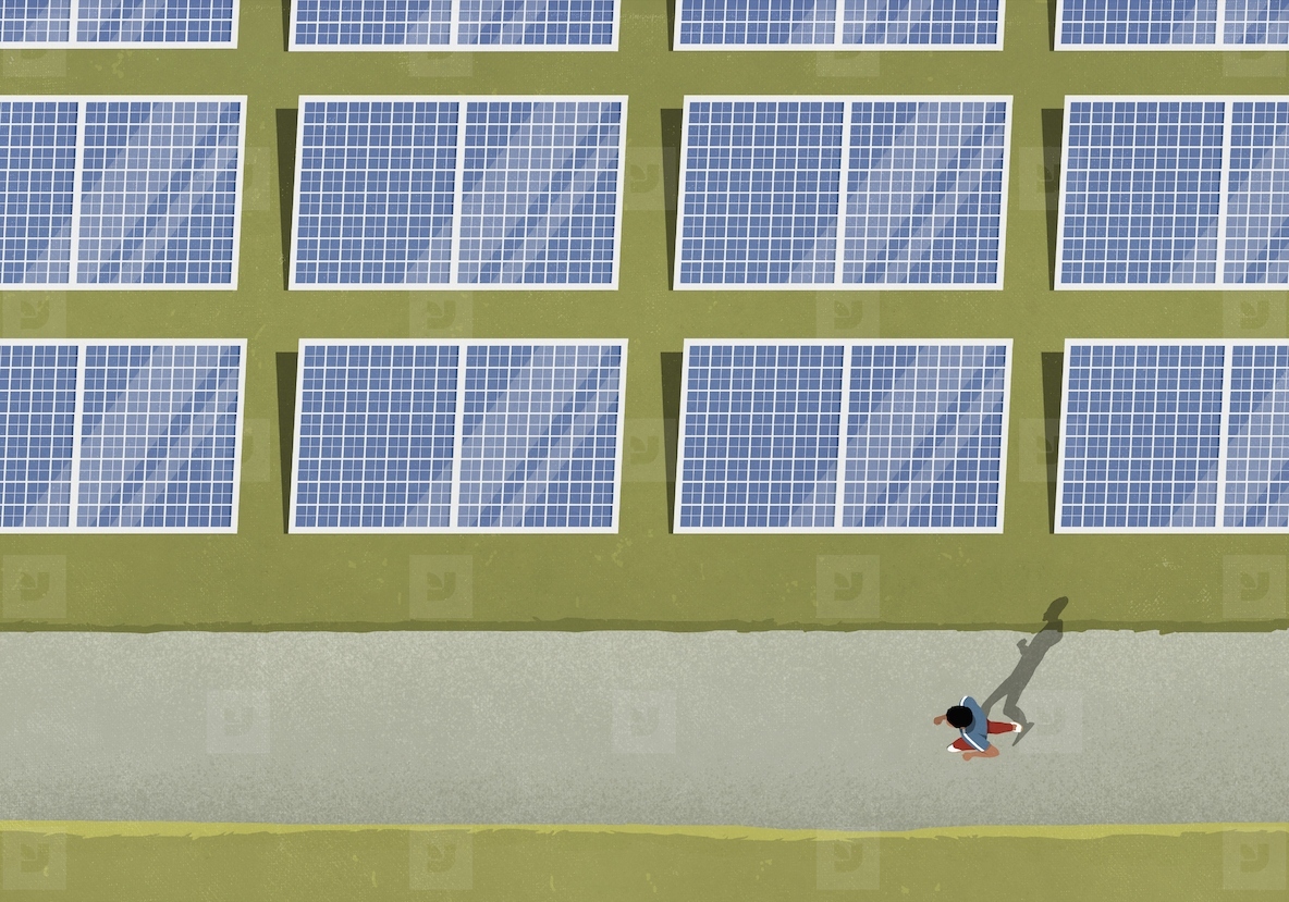 View from above man jogging along solar panels in field
