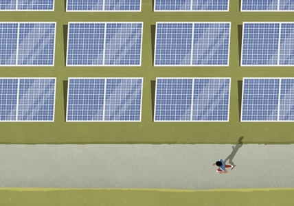 View from above man jogging along solar panels in field