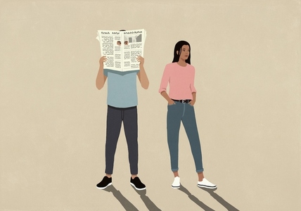 Woman standing next to man peeking through holes of newspaper