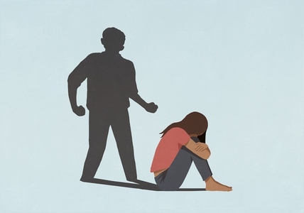 Aggressive male shadow looming over scared woman hugging knees