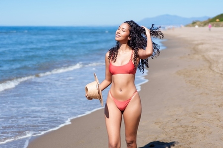 A Joyful Woman Fully Enjoying a Wonderful Day at the Beach with Her Refreshing Coconut Drink A Joyful Woman Fully Enjoying a Wonderful Day at the Beach with Her Refreshing Coconut Drink
