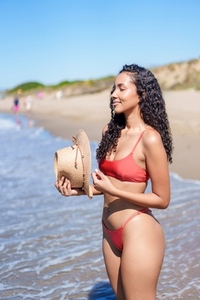 A Woman in a Stylish Swimsuit Enjoying an Amazing Day at the Beach with Vibrant Sunshine