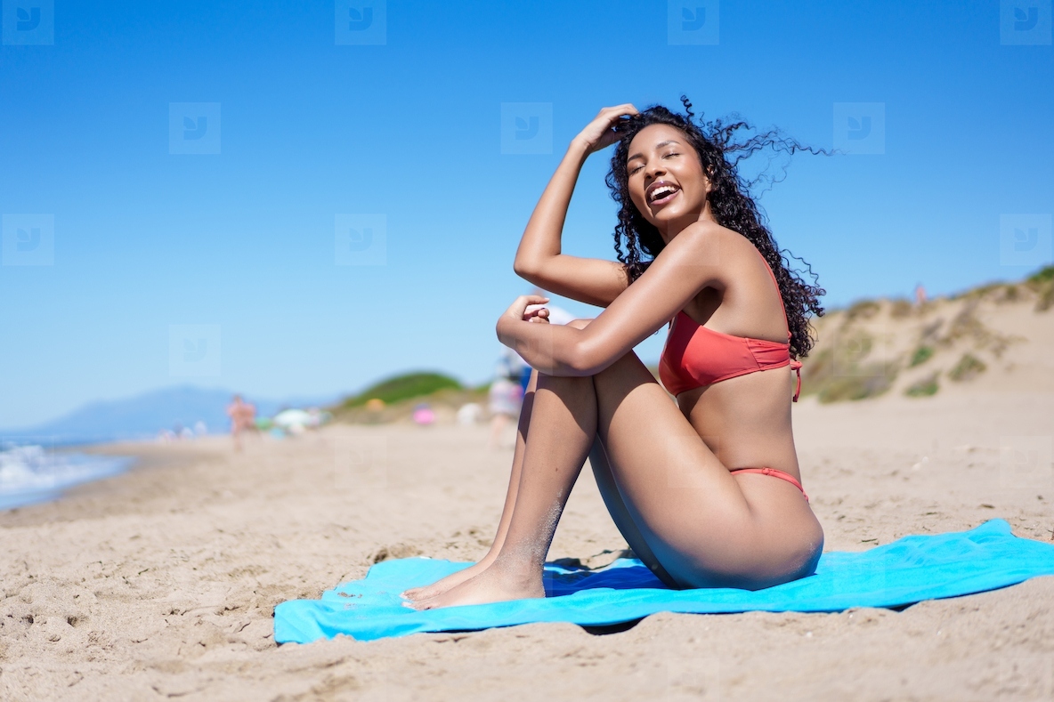 A Joyful Woman is Enjoying a Beautiful Day at the Beach in a Bright Red Bikini Ensemble