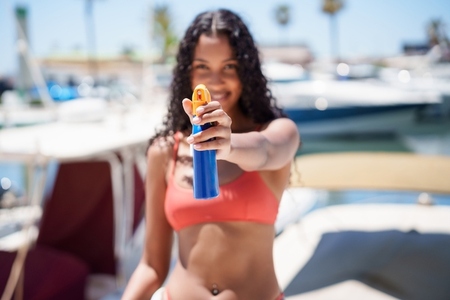 Happy Summer Vibes Woman Cheerfully Applying Sunscreen While Enjoying a Day on a Boat