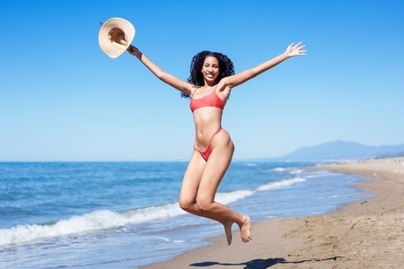 A Joyful Woman Jumping Happily on the Beautiful Beach During the Vibrant Summer Season