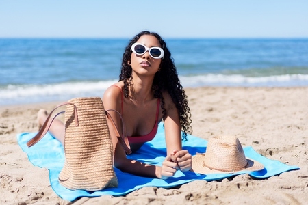 A Relaxing Beach Day A Young Woman Enjoys the Warm Sunshine by the Waters Edge