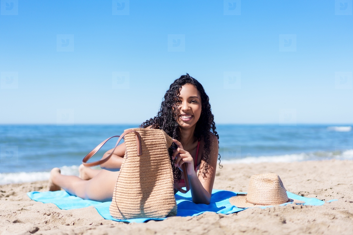 A Woman is Enjoying a Wonderful and Relaxing Day at the Beautiful Beach with a Stylish Straw Bag