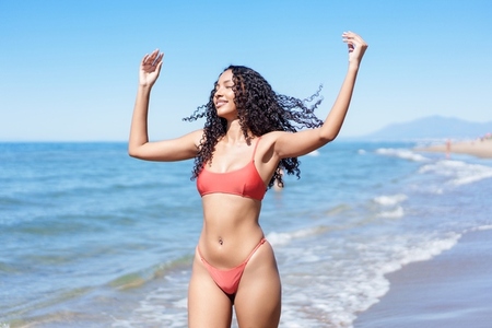 A Joyful Young Woman Happily Enjoying a Relaxing Day at the Beautiful Beach in a Bright Red Bikini A Joyful Young Woman Happily Enjoying a Relaxing Day at the Beautiful Beach in a Bright Red Bikini