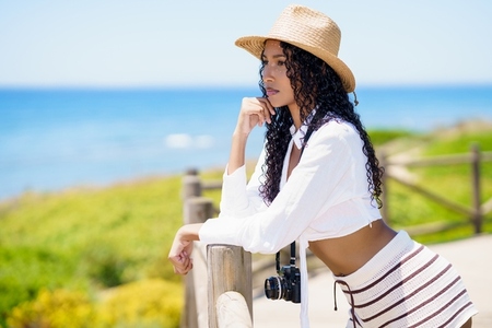 Serene Coastal Beauty A Young Woman Joyfully Enjoying a Relaxing Summer Day by the Sea