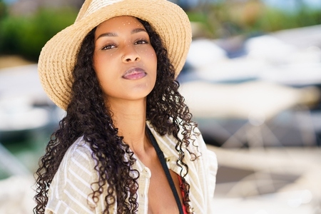 An Elegant Woman Wearing a Straw Hat by the Beautiful Marina in the Afternoon Light An Elegant Woman Wearing a Straw Hat by the Beautiful Marina in the Afternoon Light