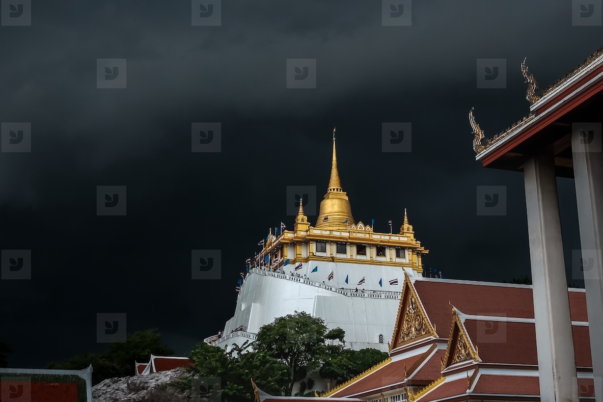 Golden mountain in Wat Saket Bangkok Thailand covered with dark