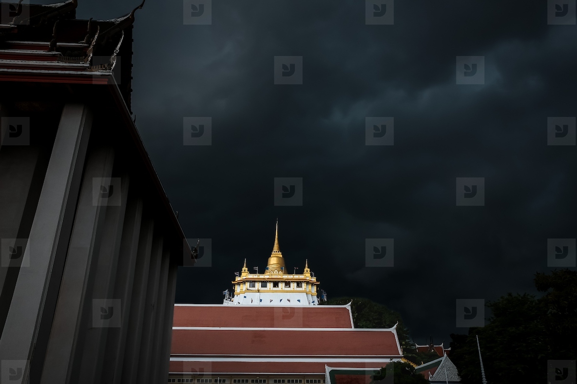 Golden mountain in Wat Saket Bangkok Thailand covered with dark